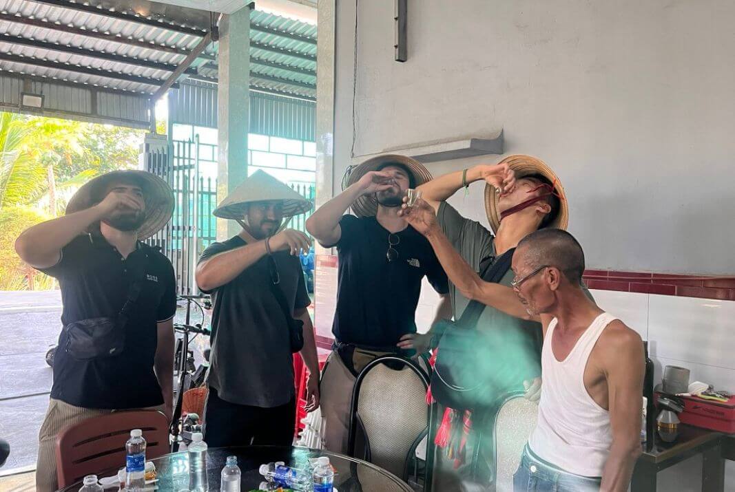 Tourists experiencing local rice wine culture Drinking with local